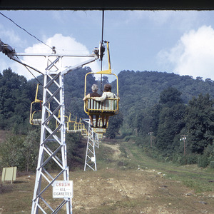People on chair lift in mountains, circa October 1971