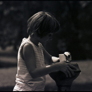 Child at water fountain, circa 1969-1975