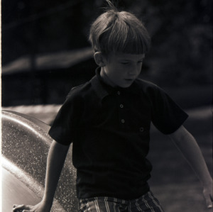 Child playing on slide, circa 1969-1975