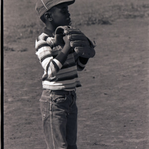 Child playing baseball, circa 1969-1975
