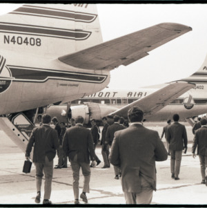Football players boarding a plane, circa 1969-1975