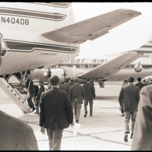 Football players boarding a plane, circa 1969-1975