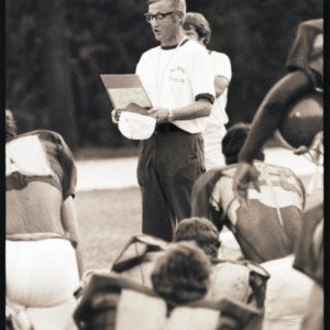 Football coach and players at practice, 1973