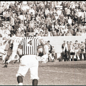 Football players and referee at homecoming game, circa 1969-1975