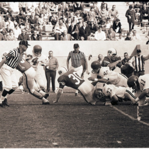 Football players and referees at homecoming game, circa 1969-1975
