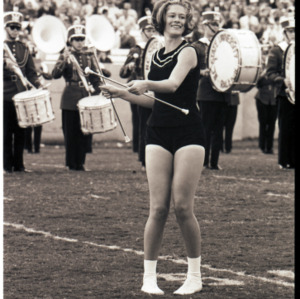 Marching band and cheerleader on field, circa 1969-1975