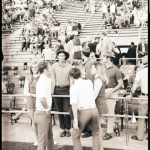 Marching band and cheerleaders at football game, 1969