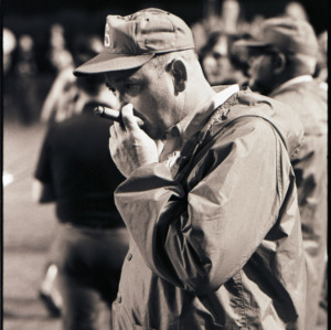Football coach smoking cigar at NC State versus East Carolina game, circa 1969-1975