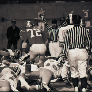 Football players and referees at NC State versus East Carolina game, circa 1969-1975