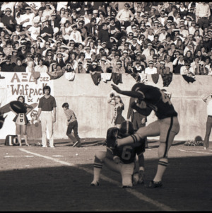 Football players and spectators at NC State versus East Carolina game, circa 1969-1975