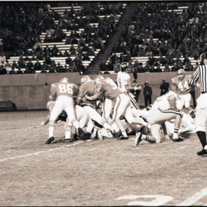 Football players and referee at NC State versus East Carolina game, circa 1969-1975