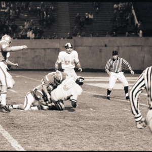 Football players and referees at NC State versus East Carolina game, circa 1969-1975