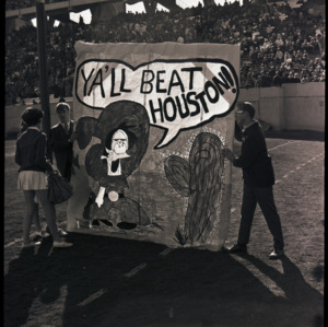 Poster and spectators at NC State versus Houston football game, circa 1969-1975