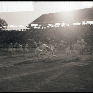 Double exposure of football players and referees at NC State versus Houston game, circa 1969-1975
