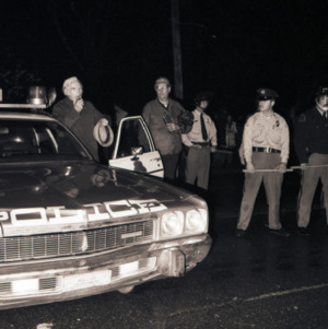 John Caldwell at loudspeaker with police officers at celebration after victory over UCLA, March 23, 1974