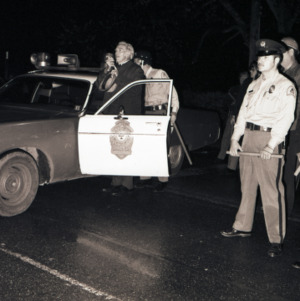 John Caldwell at loudspeaker with police officers at celebration after victory over UCLA, March 23, 1974