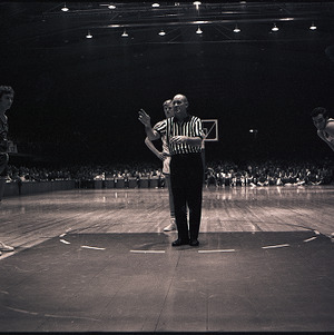 Basketball players and referee at NC State vs. Atlantic Christian, circa 1969-1975