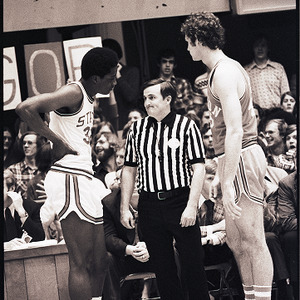 Basketball players and referee at NC State vs. Clemson, circa 1972-1975