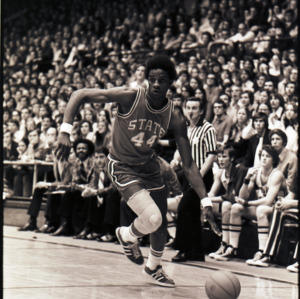 Basketball player, referee, and spectators at NC State versus Duke game, circa 1972-1975