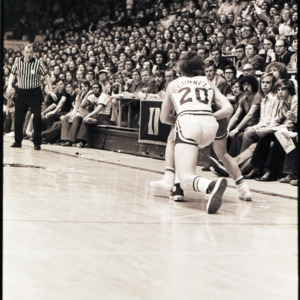 Basketball players, referee, and spectators at NC State versus Duke game, circa 1972-1975