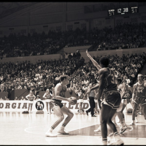 Basketball players feat. Bob Heats, Billy Mitchell and referee at NC State vs. Georgia game, circa 1972-1973