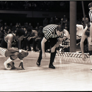 Basketball players and referees on court at NC State versus Lehigh game, circa 1972-1973