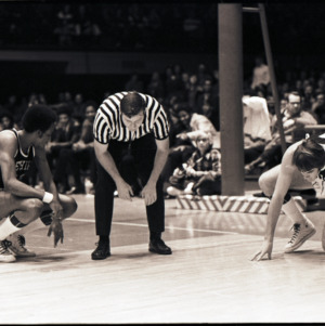 Basketball players and referees on court at NC State versus Lehigh game, circa 1972-1973
