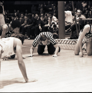 Basketball players and referee on court at NC State versus Lehigh game, circa 1972-1973