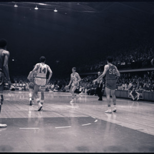 Basketball players and referee at NC State versus Maryland game, circa 1969