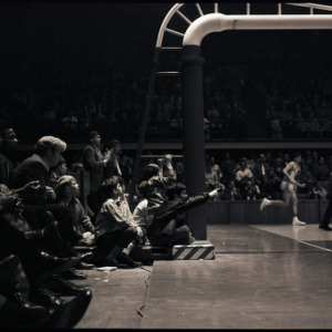 Children and spectators watching basketball player and referee at NC State versus Maryland game, circa 1969