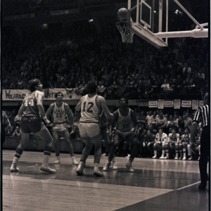 Basketball players and referee at NC State versus Maryland game, circa 1969-1975