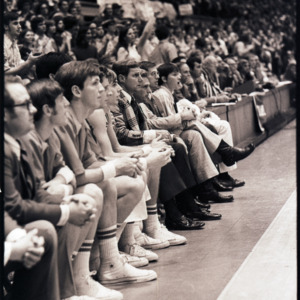 Basketball players, coach, and spectators at NC State versus Maryland game, circa 1972-1975