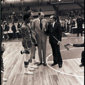 Interviewer with basketball coach and players at NC State versus Maryland ACC title game, 1973