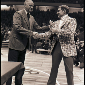 Basketball coach receiving award at NC State versus Maryland ACC title game, 1973