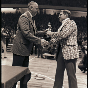 Basketball coach receiving award at NC State versus Maryland ACC title game, 1973
