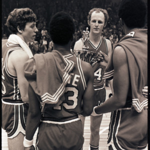 Basketball players with trophy at NC State versus Maryland ACC title game, 1973