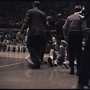 Basketball coaches and player at NC State versus UNC-Chapel Hill game, circa 1969