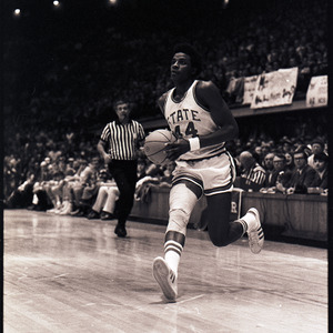 Basketball player and referee at NC State versus UNC-Chapel Hill game, circa 1971-1973