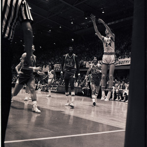 Basketball players and referee at NC State versus UNC-Chapel Hill game, circa 1971-1973