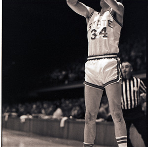 Basketball player and referee at NC State versus UNC-Chapel Hill game, circa 1973-1974