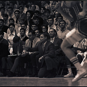 Basketball coaches, players, and spectators at NC State versus UNC-Chapel Hill game, circa 1969-1975