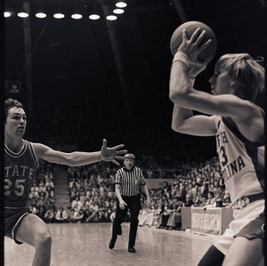 Basketball players and referee at NC State versus UNC-Chapel Hill game, circa 1972-1975