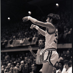 Basketball player and referee at NC State versus UNC-Chapel Hill game, circa 1972-1975