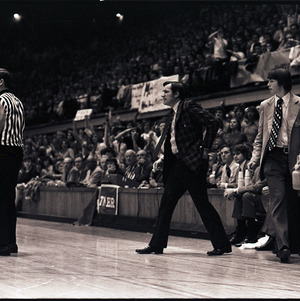 Basketball coaches, referee, and player at NC State versus UNC-Chapel Hill game, circa 1972-1975
