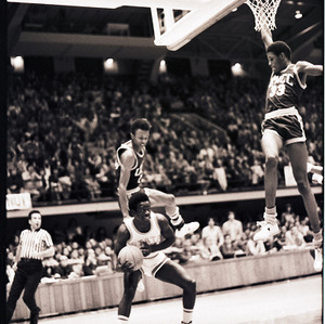 Basketball players and referee at NC State vs. UNC-Charlotte game, circa 1972-1974