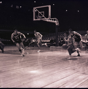 Basketball players and referee at NC State versus University of Florida game, circa 1969