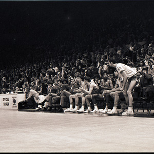 Basketball players, referee, and spectators at NC State versus University of South Carolina game, circa 1969