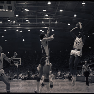 Basketball players and referee at NC State versus University of South Carolina game, circa 1969