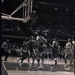 Basketball players and referee at NC State versus University of South Carolina game, 1970 or 1971