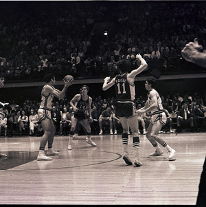 Basketball players and referee at NC State versus University of South Carolina game, 1970 or 1971
